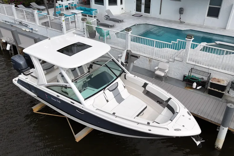 Slide: The Image of 2023 Chaparral 300 OSX boat docked by a waterfront home with pool. - 8