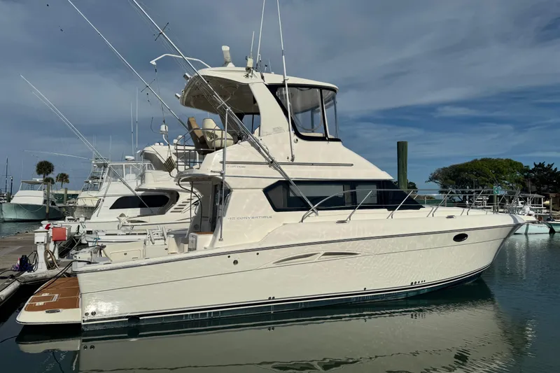 The Image of 2008 Silverton 42 Convertible yacht docked at marina under clear sky. - 0