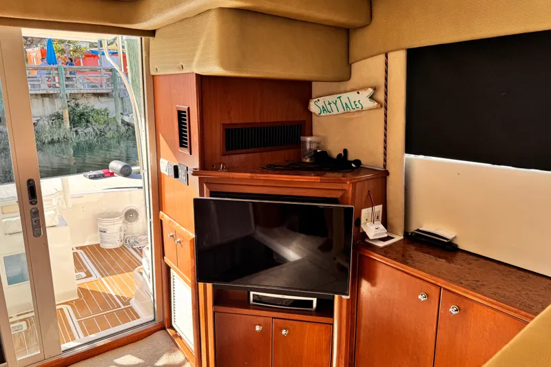 Slide: The Image of Interior of 2008 Silverton 42 Convertible yacht with TV and wooden cabinetry. - 13