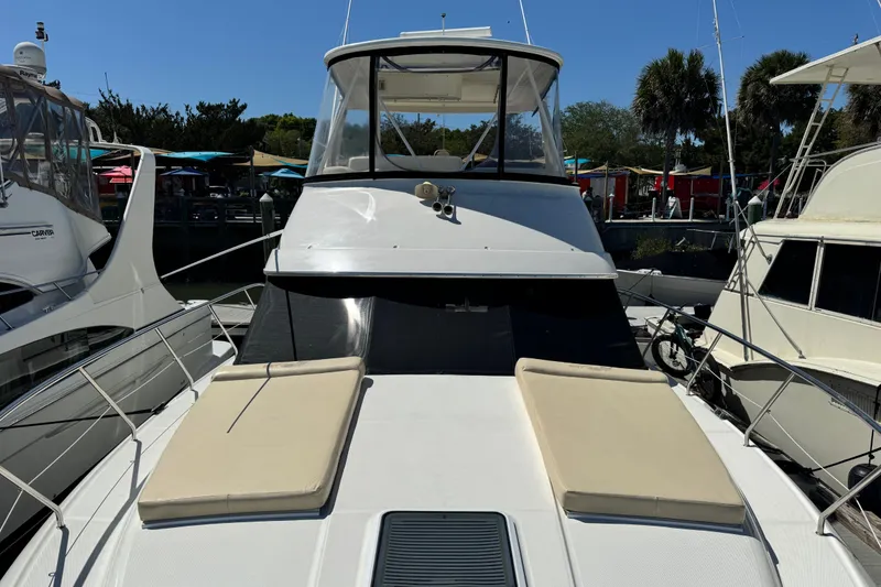Slide: The Image of 2008 Silverton 42 Convertible yacht docked, featuring spacious deck and sleek design. - 2