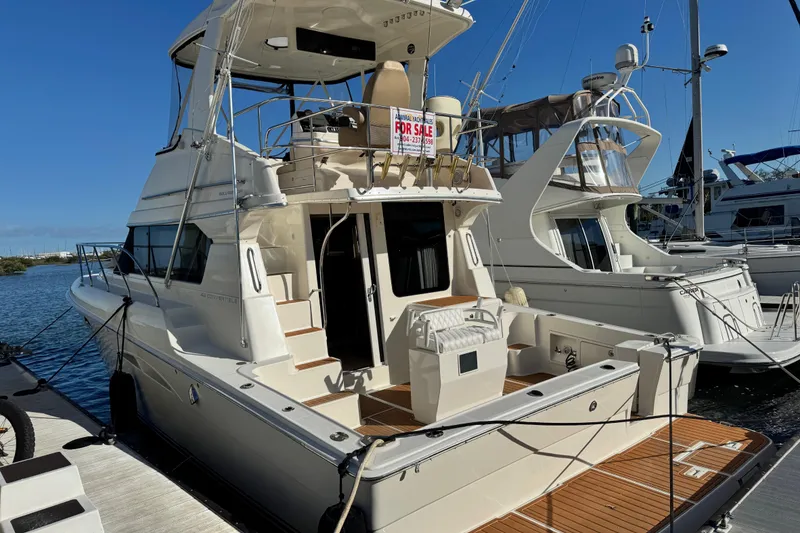 Slide: The Image of 2008 Silverton 42 Convertible yacht docked, featuring spacious deck and "For Sale" sign. - 3