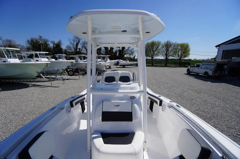 Slide: The Image of 2025 Tidewater 210 CC Adventure boat with T-top, parked in a gravel lot. - 11