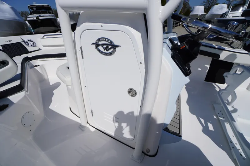 Slide: The Image of 2025 Tidewater 210 CC Adventure boat interior with steering wheel and storage compartment. - 13