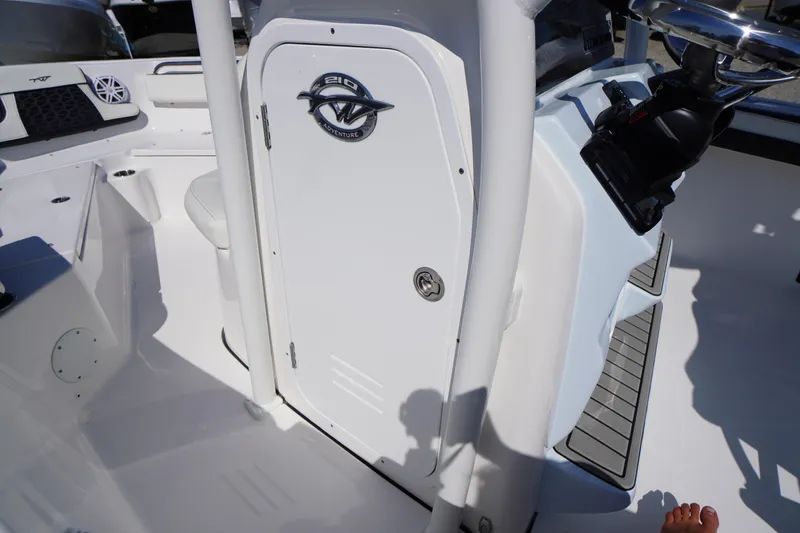 Slide: The Image of 2025 Tidewater 210 CC Adventure boat interior with steering console and seating area. - 14