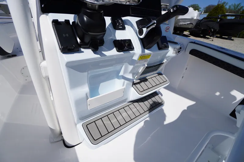 Slide: The Image of 2025 Tidewater 210 CC Adventure boat console with controls and footrests. - 19