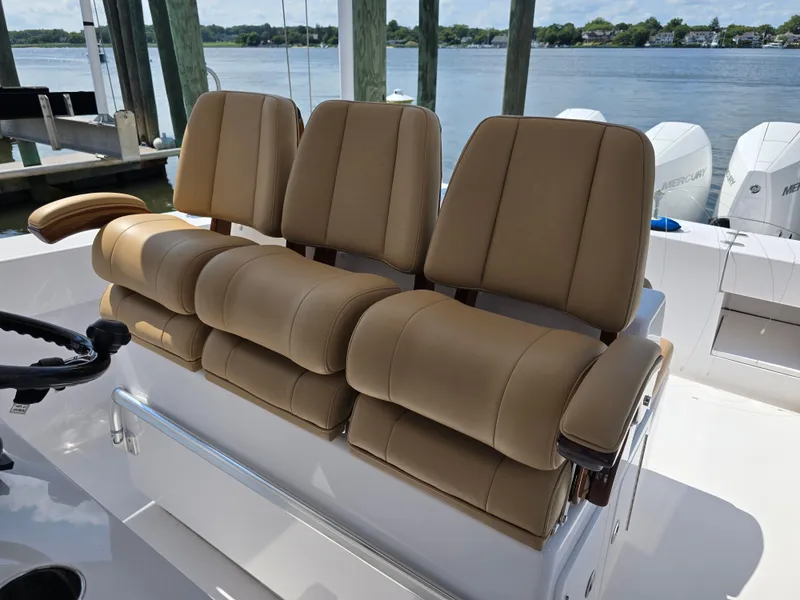 Slide: The Image of 2025 Bahama 35 Super Center Console boat with tan seating, docked by the water. - 11