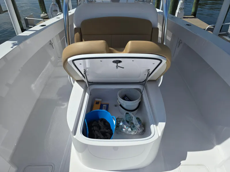 Slide: The Image of 2025 Bahama 35 Super Center Console storage compartment with open hatch, showcasing interior items. - 8