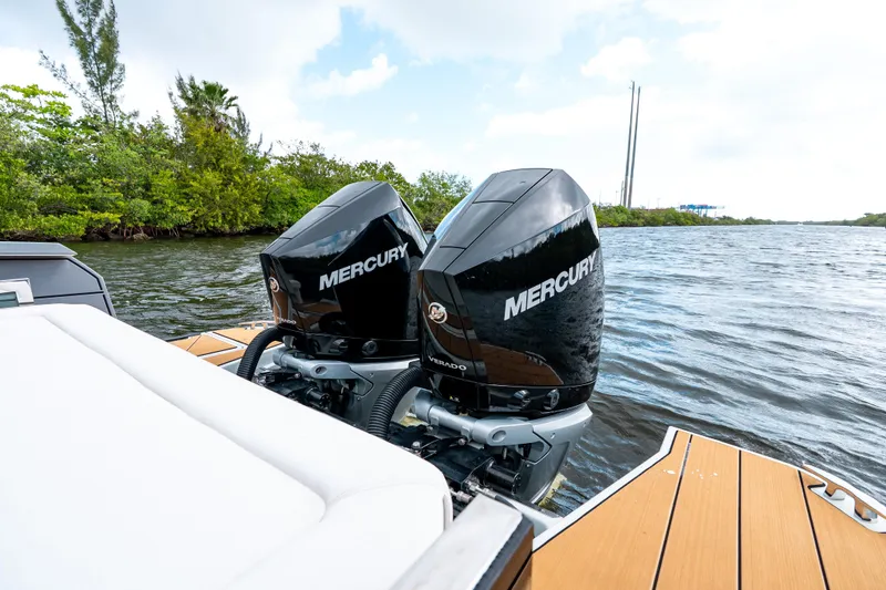 Slide: The Image of 2024 Saxdor 320 GTO with dual Mercury outboard engines on a scenic waterway. - 13