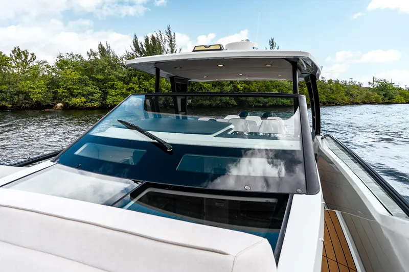 Slide: The Image of 2024 Saxdor 320 GTO yacht cruising on a scenic river with lush greenery. - 25