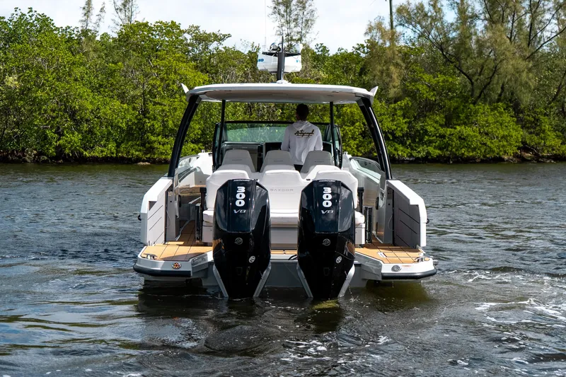 Slide: The Image of 2024 Saxdor 320 GTO boat with dual 300 V8 engines on a scenic waterway. - 4