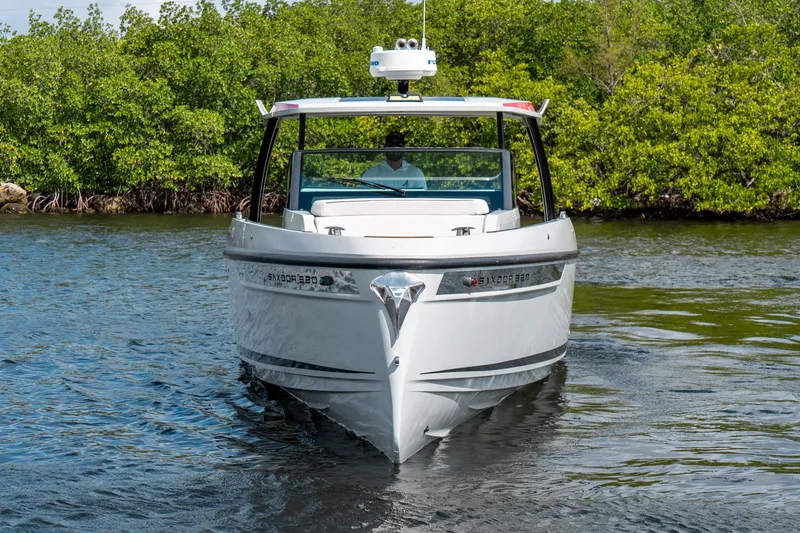 Slide: The Image of 2024 Saxdor 320 GTO boat cruising on a calm river with lush greenery. - 6