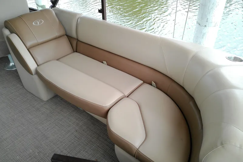 Slide: The Image of 2016 Veranda Relax V2275RC boat interior with beige and brown seating by the water. - 17