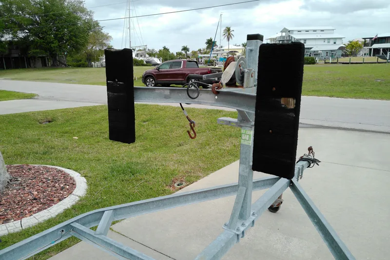 Slide: The Image of Boat trailer with winch and padded supports, parked on a driveway. - 24