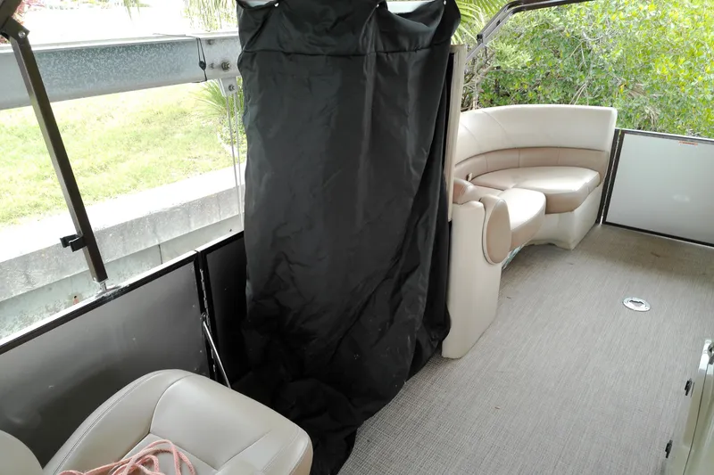 Slide: The Image of Interior of a 2016 Veranda Relax V2275RC pontoon boat with beige seating and black curtain. - 5