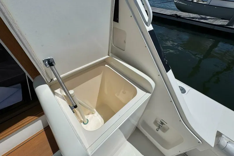 Slide: The Image of Open storage compartment on 1989 Bertram 50 Convertible yacht, docked by the water. - 14