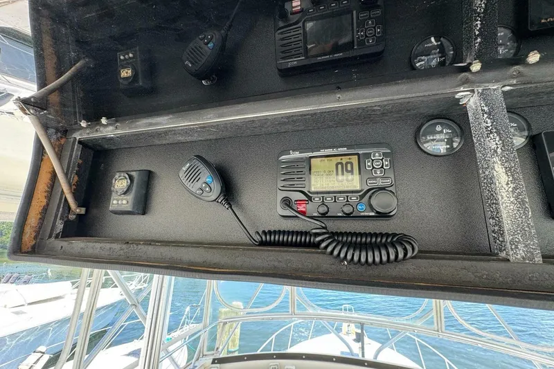 Slide: The Image of Control panel of a 1989 Bertram 50 Convertible boat with radio and gauges. - 19
