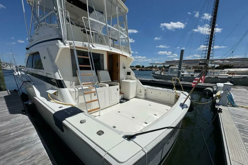 Slide: The Image of 1989 Bertram 50 Convertible yacht docked at marina under clear blue sky. - 2