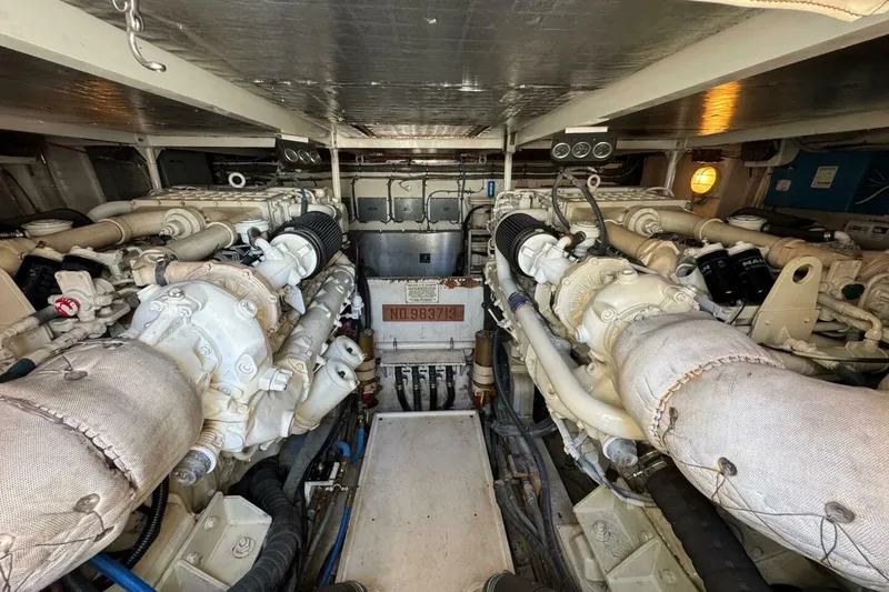 Slide: The Image of Engine room of a 1989 Bertram 50 Convertible yacht, showcasing dual engines and mechanical components. - 3