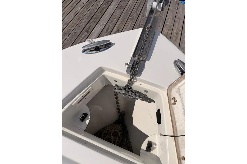Slide: The Image of Anchor chain compartment on a 2005 Sailfish 236 CC boat, docked on wooden pier. - 10