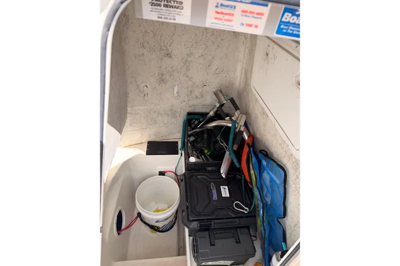 Slide: The Image of Storage compartment of a 2005 Sailfish 236 CC boat with various tools and equipment. - 11