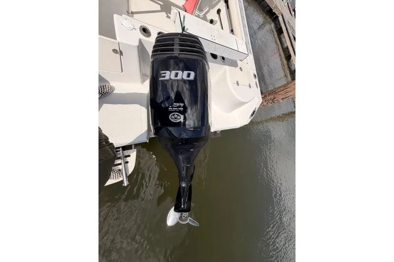 Slide: The Image of Outboard motor on 2005 Sailfish 236 CC boat, docked on calm water. - 12