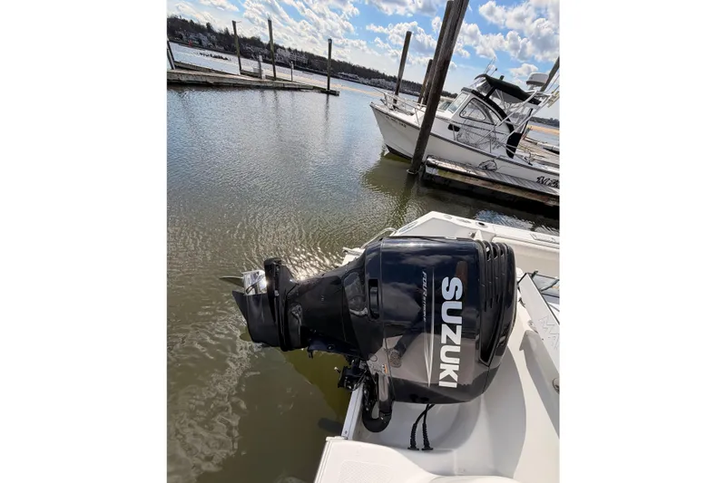 Slide: The Image of Outboard motor on 2005 Sailfish 236 CC boat docked by the water. - 15