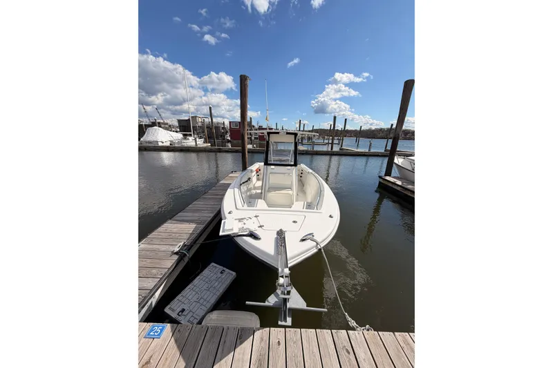 Slide: The Image of 2005 Sailfish 236 CC boat docked at marina under clear blue sky. - 3