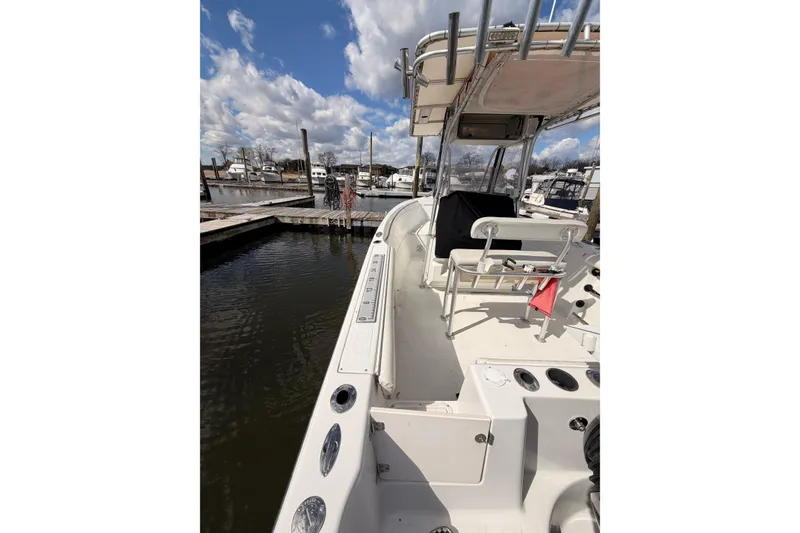 Slide: The Image of 2005 Sailfish 236 CC boat docked at marina under blue sky with clouds. - 4