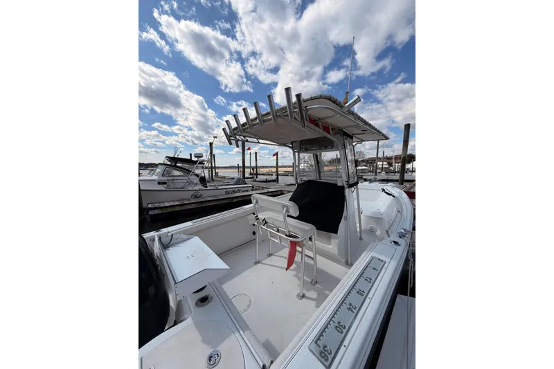 Slide: The Image of 2005 Sailfish 236 CC boat docked under a partly cloudy sky. - 5