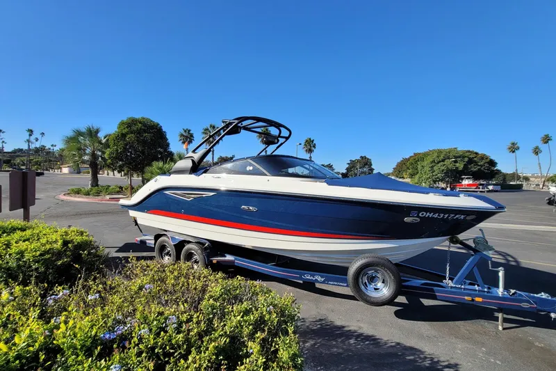 The Image of 2017 25' Sea Ray 250 SLX boat on trailer in sunny parking lot. - 1