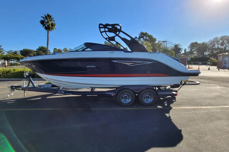 Slide: The Image of 2017 25' Sea Ray 250 SLX boat on trailer in sunny outdoor setting. - 2