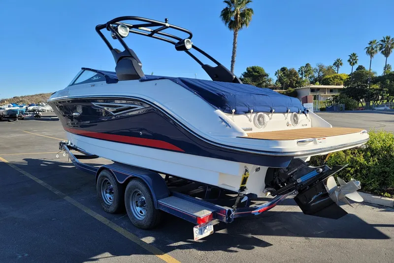 Slide: The Image of 2017 25' Sea Ray 250 SLX boat on trailer, parked outdoors with palm trees. - 3