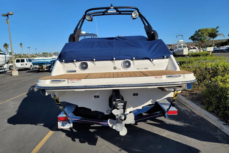 Slide: The Image of 2017 Sea Ray 250 SLX boat, rear view, parked on trailer in sunny marina. - 6