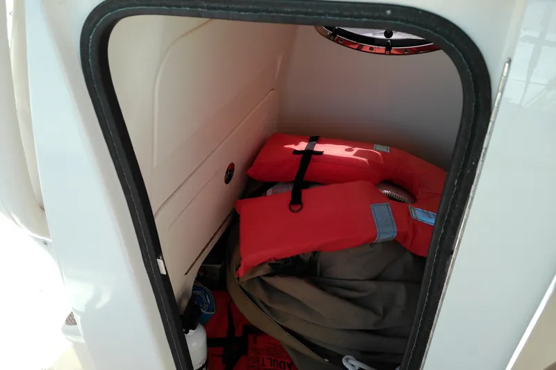 Slide: The Image of Storage compartment in a 2015 Grady-White 251 Coastal Explorer with life jackets and equipment. - 29