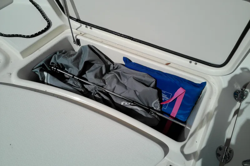 Slide: The Image of Storage compartment on a 2015 Grady-White 251 Coastal Explorer boat with gear and life jacket. - 32