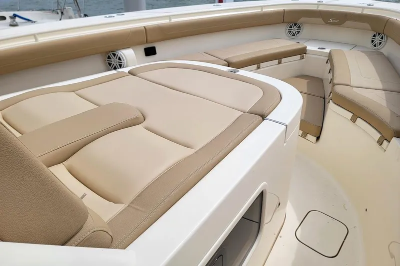 Slide: The Image of Luxurious seating on 2018 Scout 355 LXF boat, featuring beige cushions and sleek design. - 11
