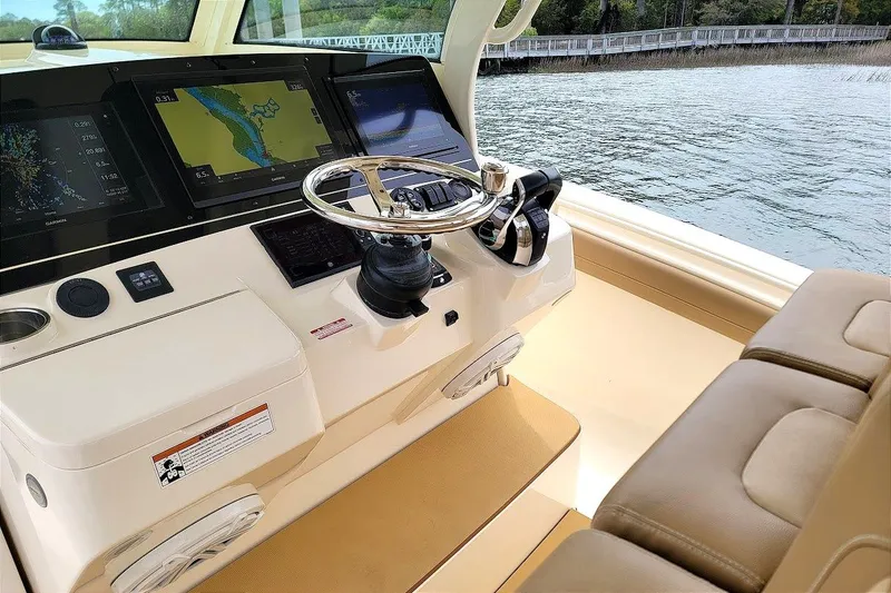 Slide: The Image of 2018 Scout 355 LXF boat helm with advanced navigation displays and steering wheel. - 17