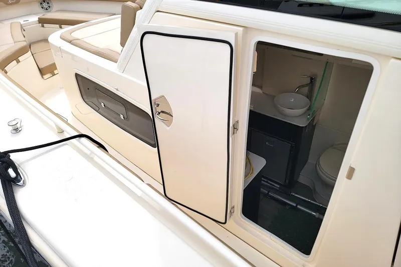 Slide: The Image of 2018 Scout 355 LXF boat interior with open cabin door, showing sink and toilet. - 18