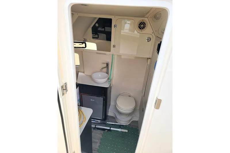 Slide: The Image of 2018 Scout 355 LXF boat interior bathroom with sink, toilet, and storage cabinets. - 20