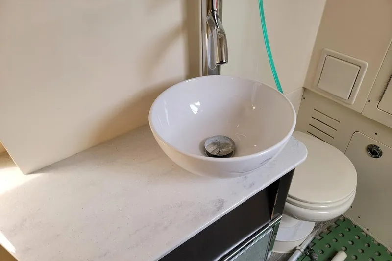 Slide: The Image of 2018 Scout 355 LXF boat bathroom with modern sink and toilet. - 23