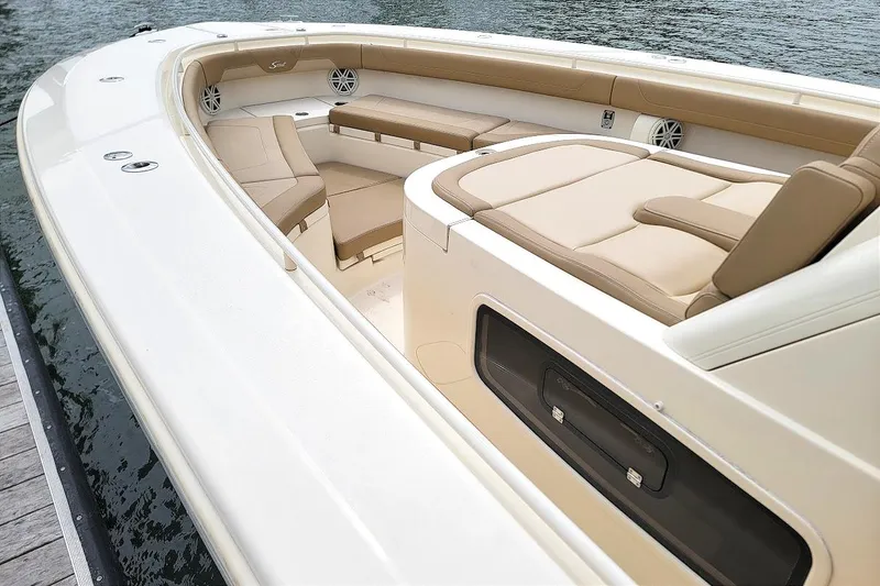 Slide: The Image of 2018 Scout 355 LXF boat interior with beige seating and storage compartments. - 26