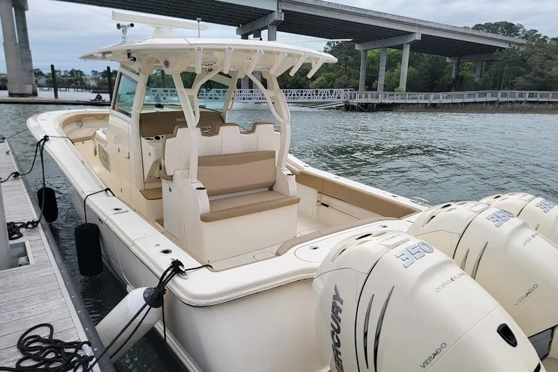 Slide: The Image of 2018 Scout 355 LXF boat docked, featuring triple Mercury 350 engines. - 27