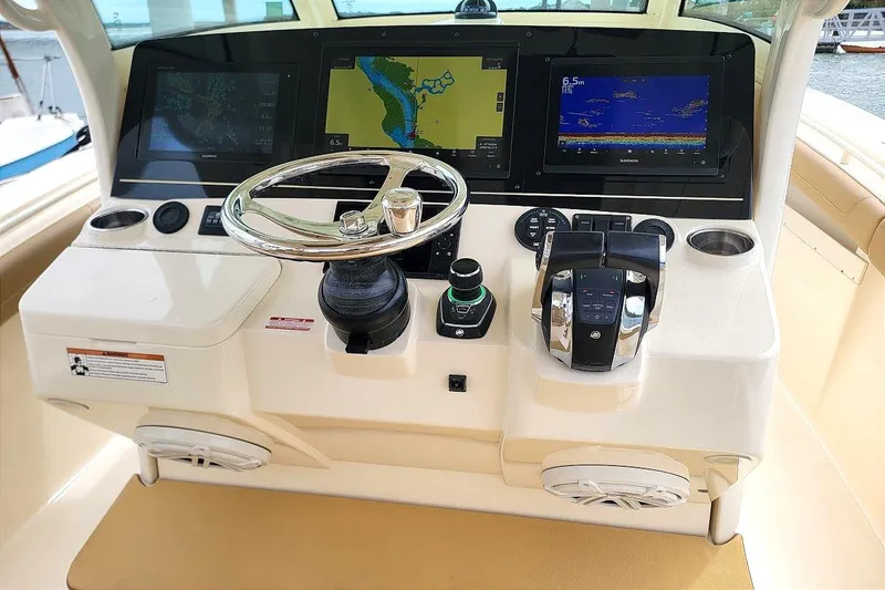 Slide: The Image of 2018 Scout 355 LXF boat dashboard with steering wheel and navigation screens. - 3