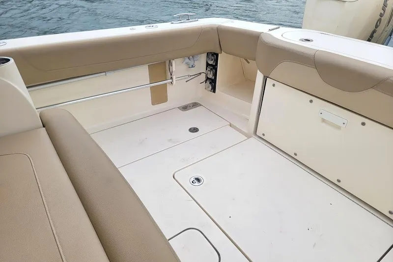 Slide: The Image of 2018 Scout 355 LXF boat interior with beige seating and storage compartments. - 33