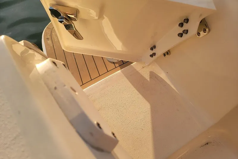 Slide: The Image of 2018 Scout 355 LXF boat deck with open hatch and metal fittings. - 35