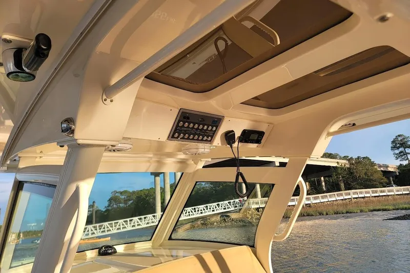Slide: The Image of Interior view of 2018 Scout 355 LXF boat with control panel and scenic background. - 38