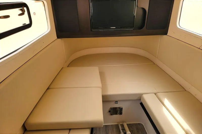 Slide: The Image of Interior cabin of 2018 Scout 355 LXF boat with beige seating and a mounted TV. - 41