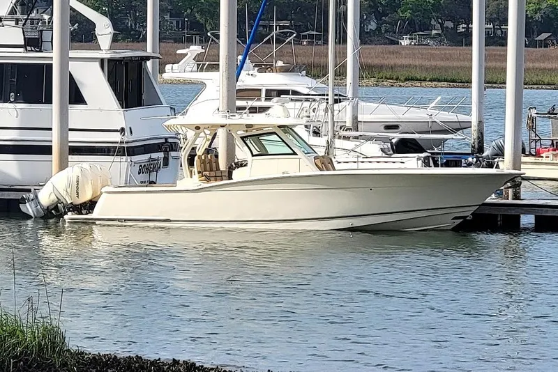 Slide: The Image of 2018 Scout 355 LXF boat docked at marina, surrounded by other vessels. - 46