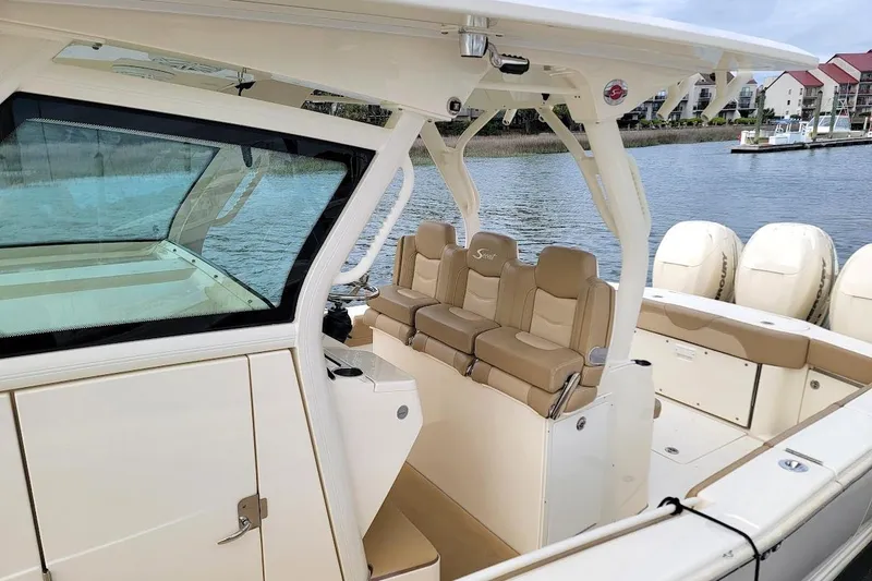 Slide: The Image of 2018 Scout 355 LXF boat interior with beige seating and multiple outboard engines. - 7