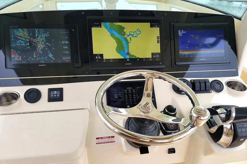 Slide: The Image of 2018 Scout 355 LXF boat dashboard with Garmin navigation displays and steering wheel. - 8